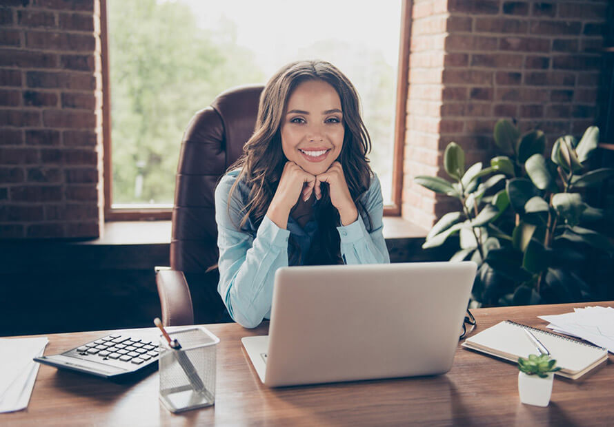 Femme souriante et épanouie à son bureau