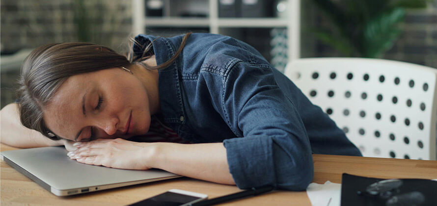 Femme fatiguée, endormie sur son bureau