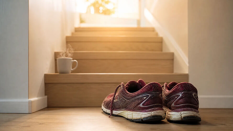 Confort : chaussures et café posés devant un escalier.